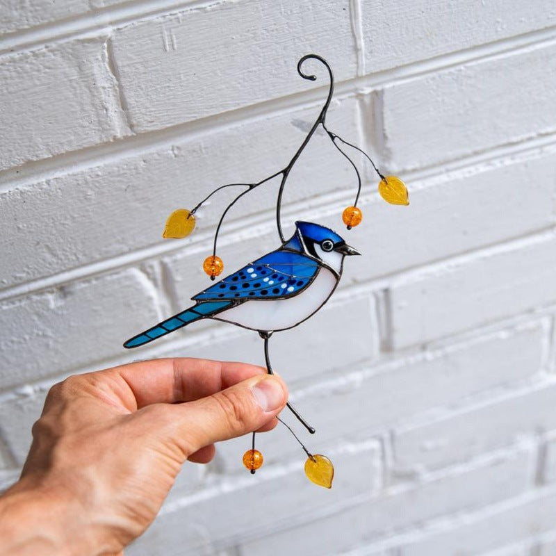 De vogeldecoratie in de hand gehouden voor een witte bakstenen muur, als schaalvergelijking