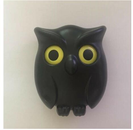 Close-up van de gele ogen en het zwarte kunststof van de uil-sleutelhouder